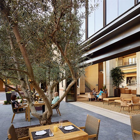 Exterior of the conference center showing the patio with some guests eating outside on a table.